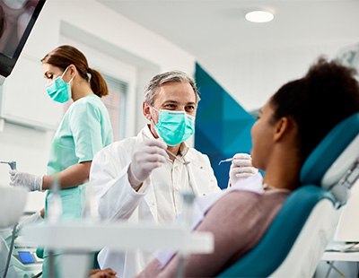 Dentist smiling at patient sitting in treatment chair